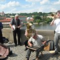 Praga - jedna z atrakcji na Moście Karola - kapela. Pan gra na tarze.